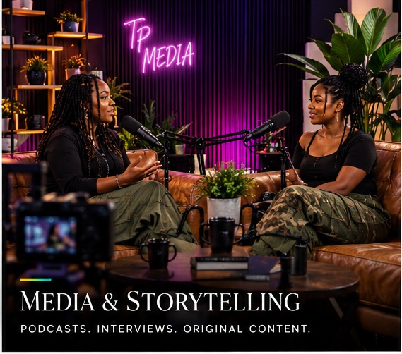 Two Black women in conversation in an upscale podcast studio, seated on a couch with professional microphones and a production workstation visible